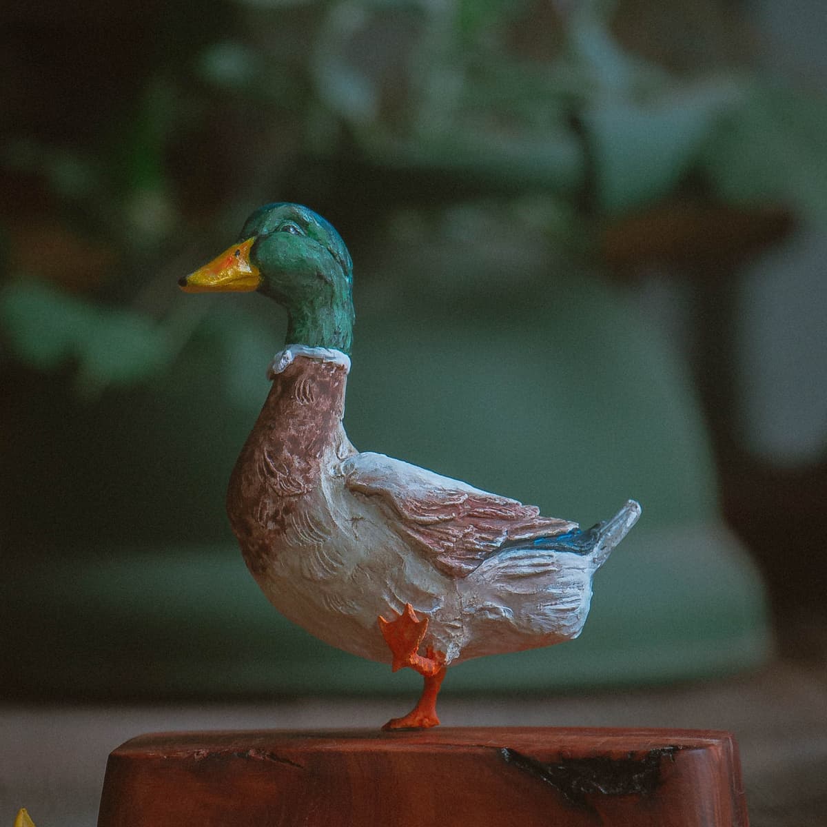 Carved and painted mallard drake figure standing on a wooden block